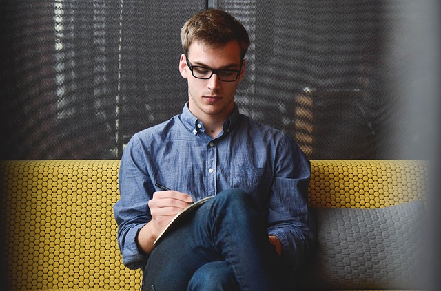 Man Sitting on a sofa with pen and paper